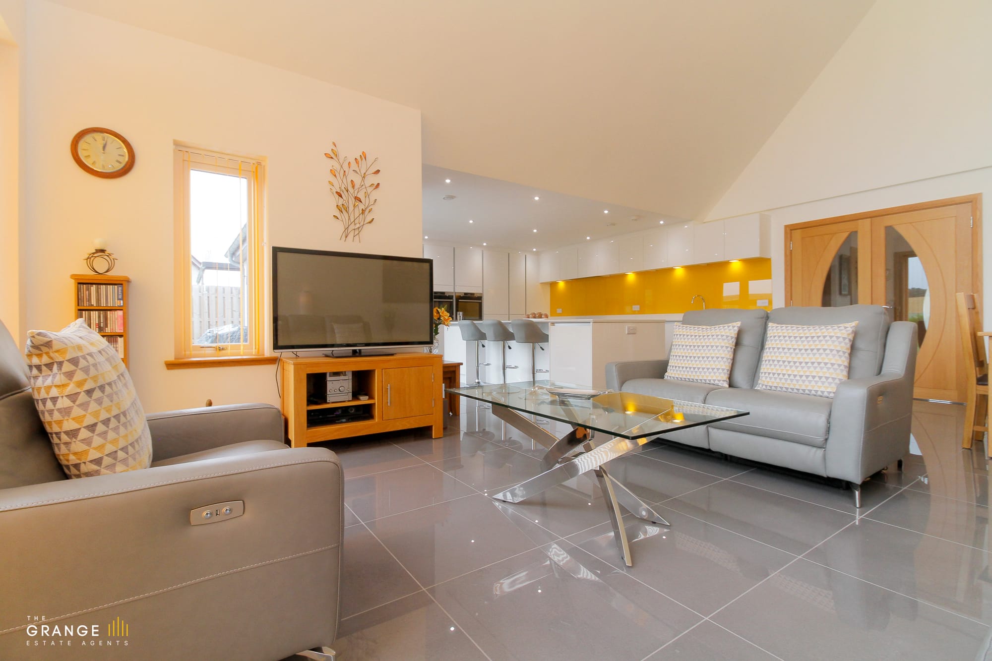 Open-plan living room with vaulted ceiling and floor to ceiling glazing