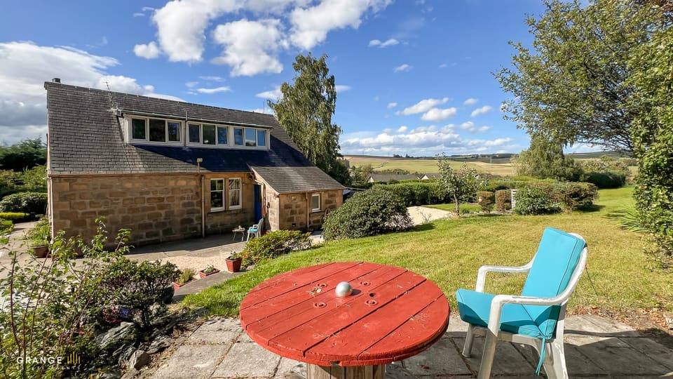 Sithean's patio and garden, with rolling countryside beyond